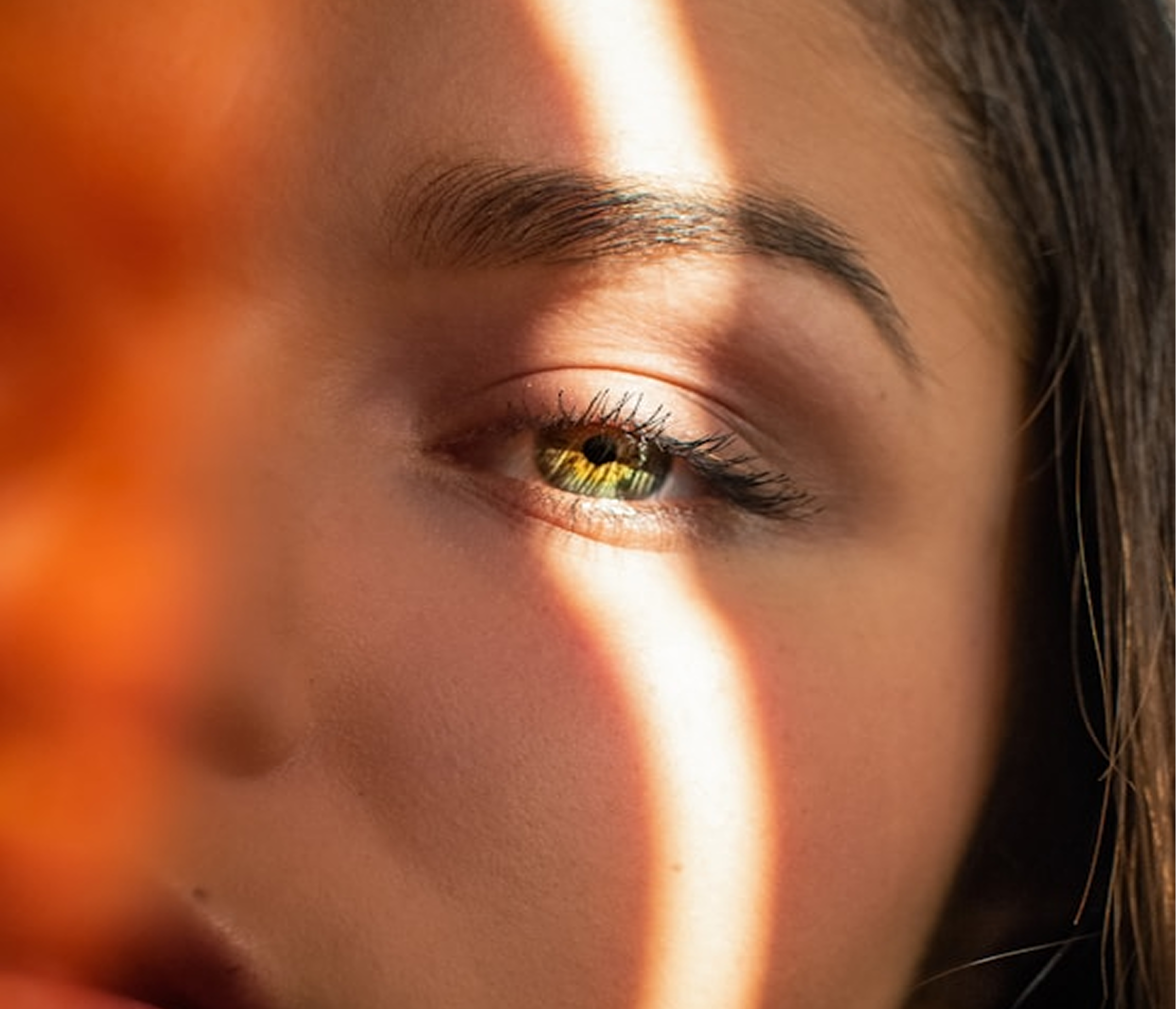 Close-up portrait with warm light across the eye