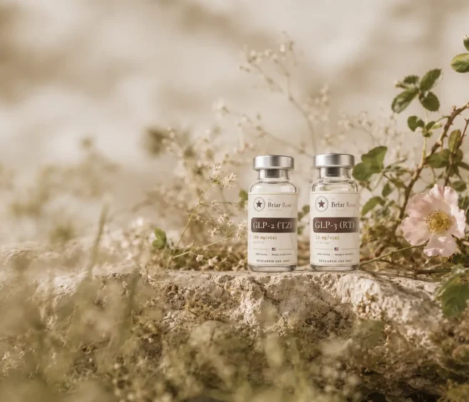 GLP-2 and GLP-3 research peptide vials displayed among wildflowers